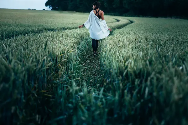 くらい草原で白い服を着た女性が後ろ姿で写っている写真